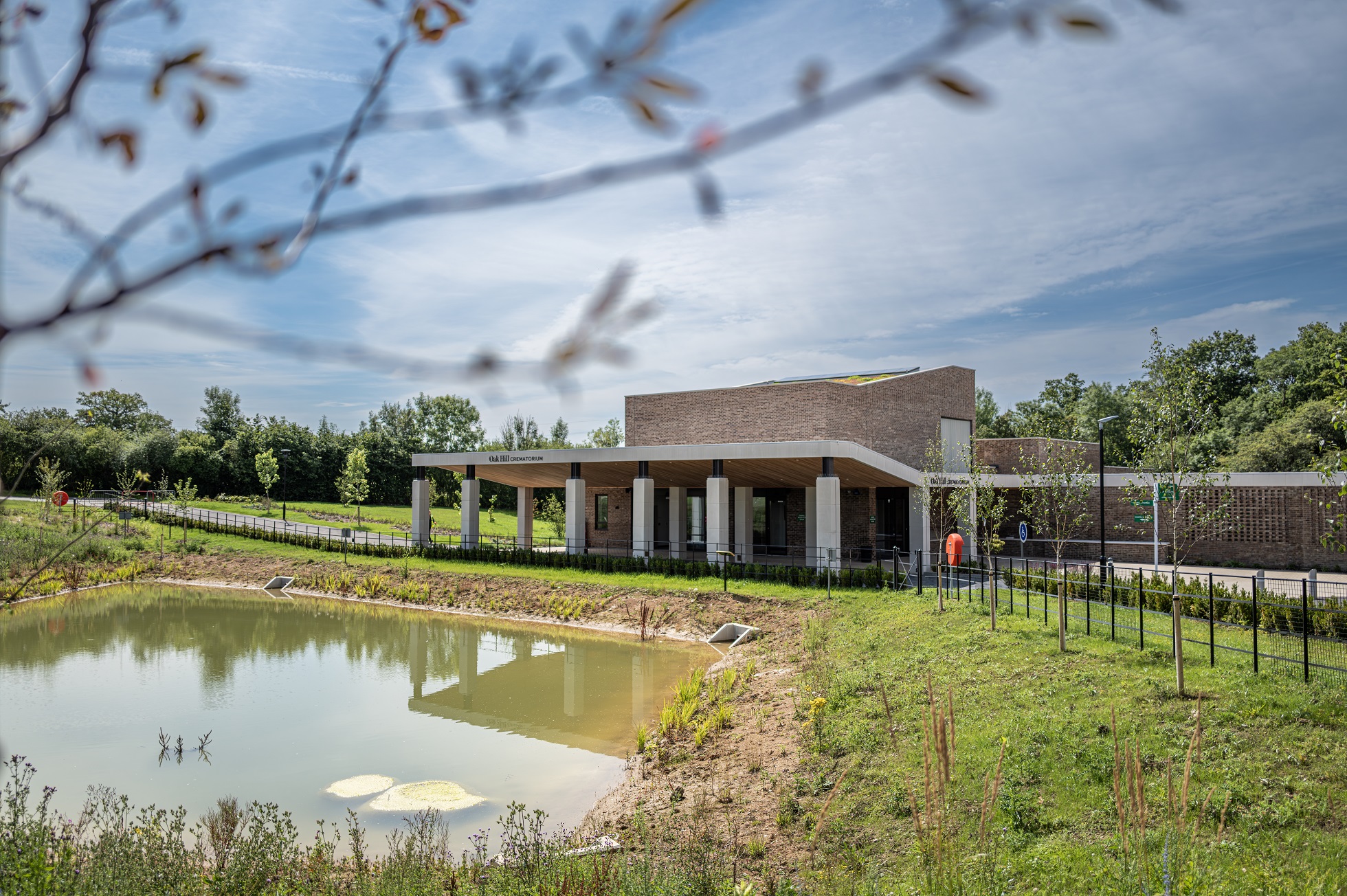 Image of Oak Hill with grass and a lake in front of it