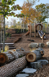 Woodland playground with children climbing on it
